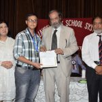 The chief guest giving away a cash prize and certificate to a high achiever of Daroghawala campus
